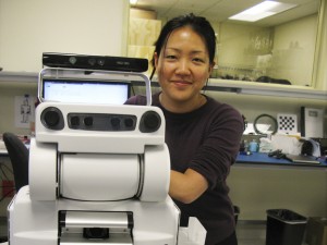 Research scientist Leila Takayama poses with a PR2 robot at Willow Garage, a robotics company in Menlo Park, Calif., that produces programmable robots.